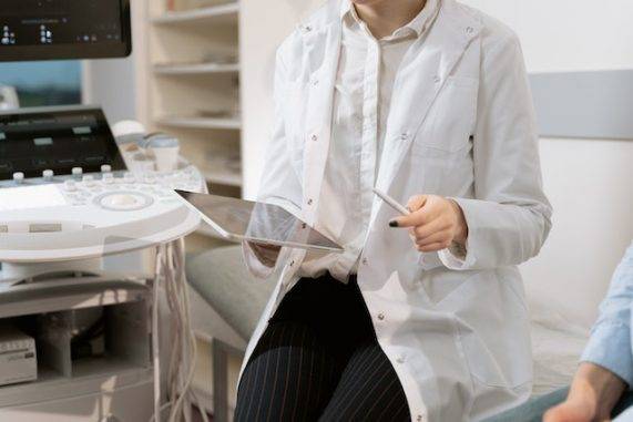 Doctor sitting near medical equipment Source